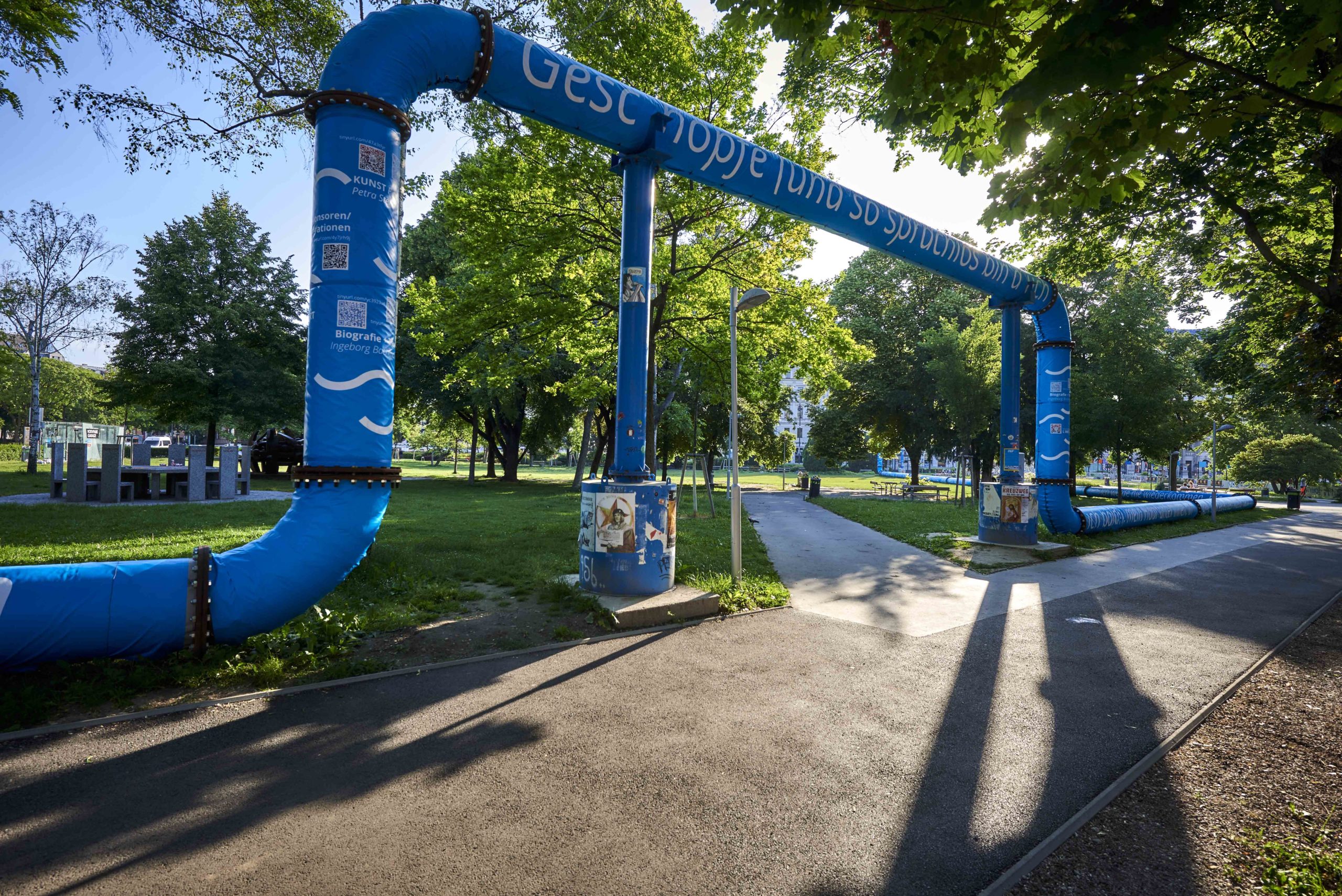 Man kann einen Ausschnitt der Rohre mit den blauen Planen sehen. Darauf sind Zitate von Ingeborg Bachmanns „Undine geht“ gedruckt. Die Rohre, welche sich in 4,5m Höhe befinden, werfen von der aufgehenden Sonne einen Schatten.