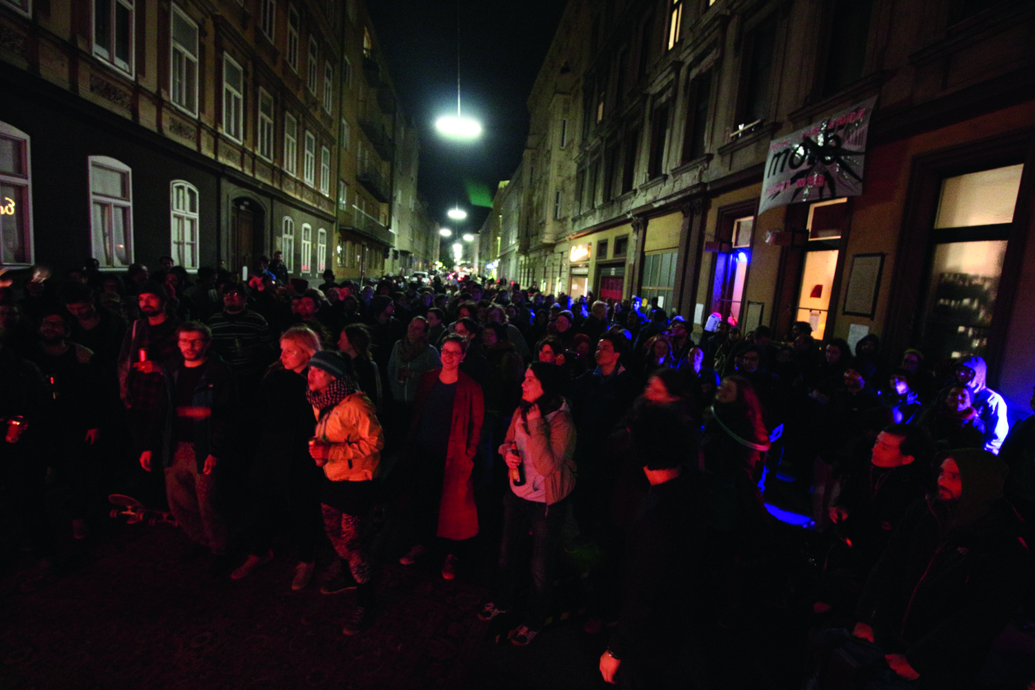 Eine große Menge an Menschen steht in der Nacht auf der Straße vor dem mo.ë und feiert