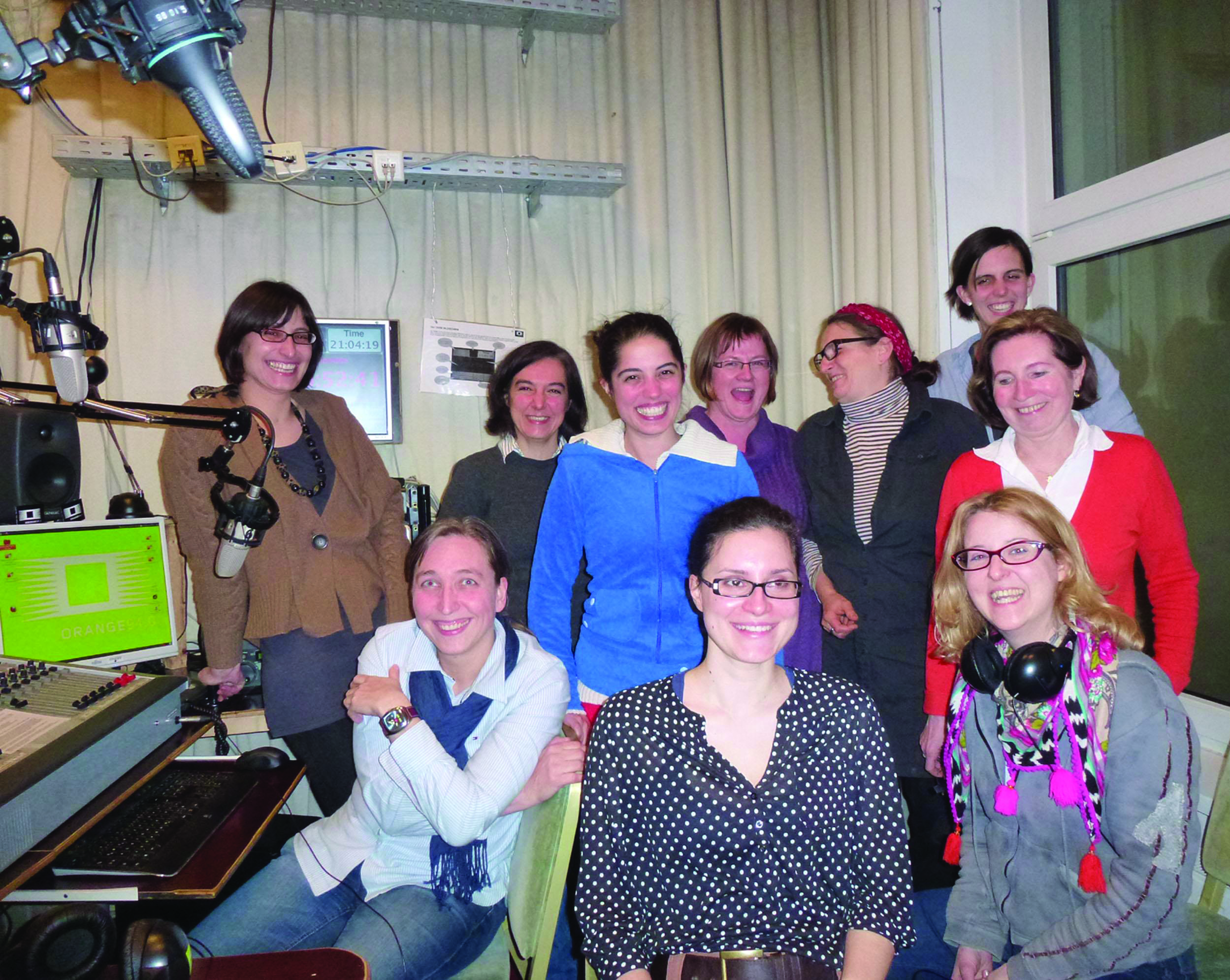 Projektteam in einem Radiostudio, alle blicken lachend in die Kamera