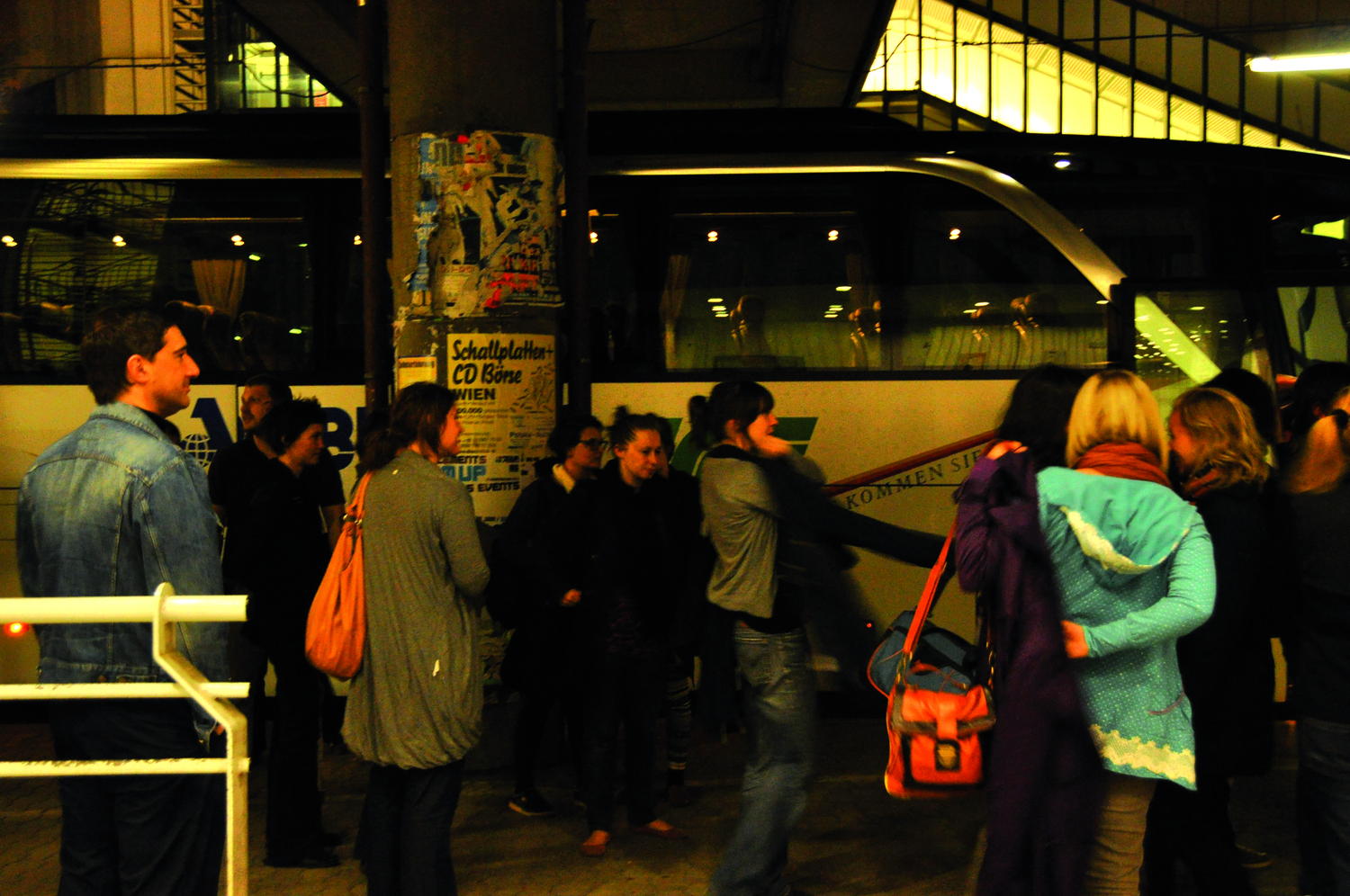 Eine Gruppe von Menschen in Alltagskleidung vor einem Reisebus