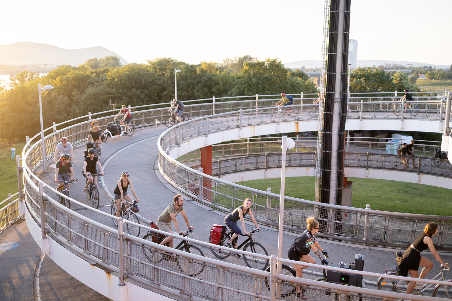 Menschen auf Rädern fahren eine spiralförmige Brücke hinunter.