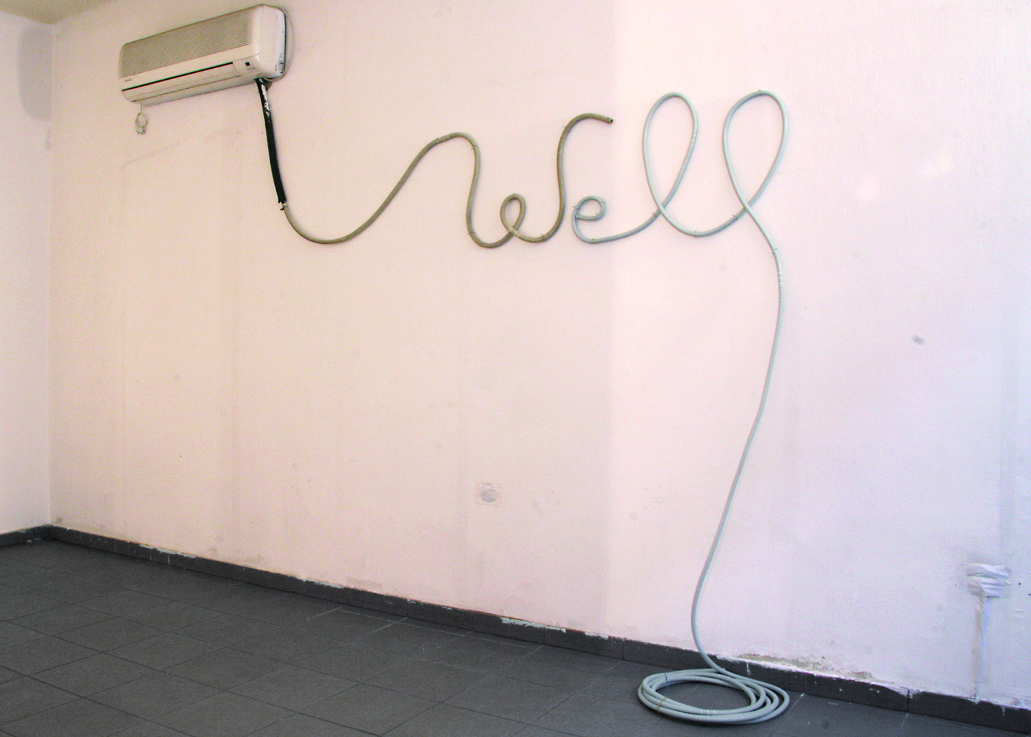 Ein Ausstellungsraum, an der weißen Wand ist eine Schriftinstallation aus Kabel, die das Wort "Well" bildet