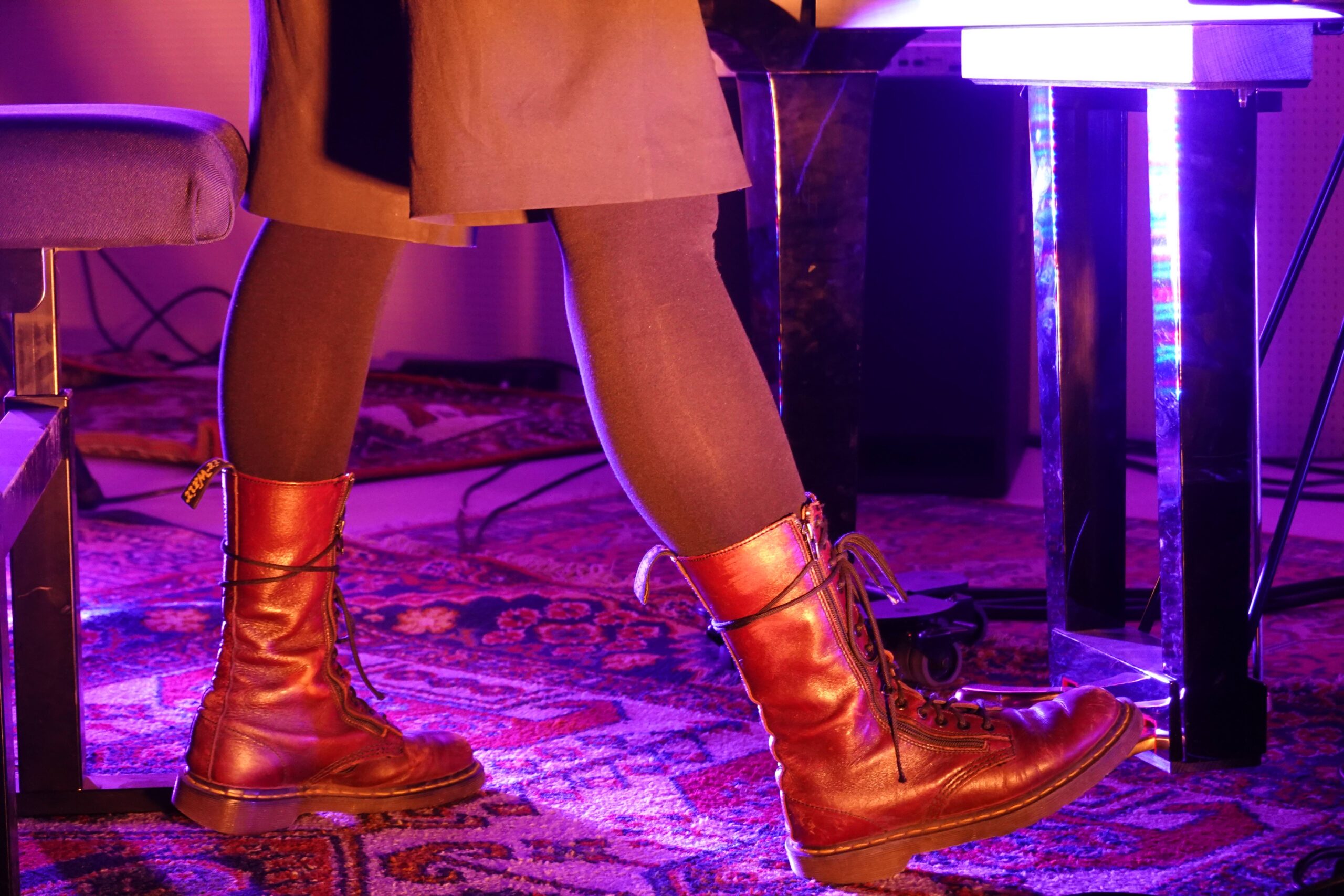 beleuchtete Stiefel vor einem Klavierpedal