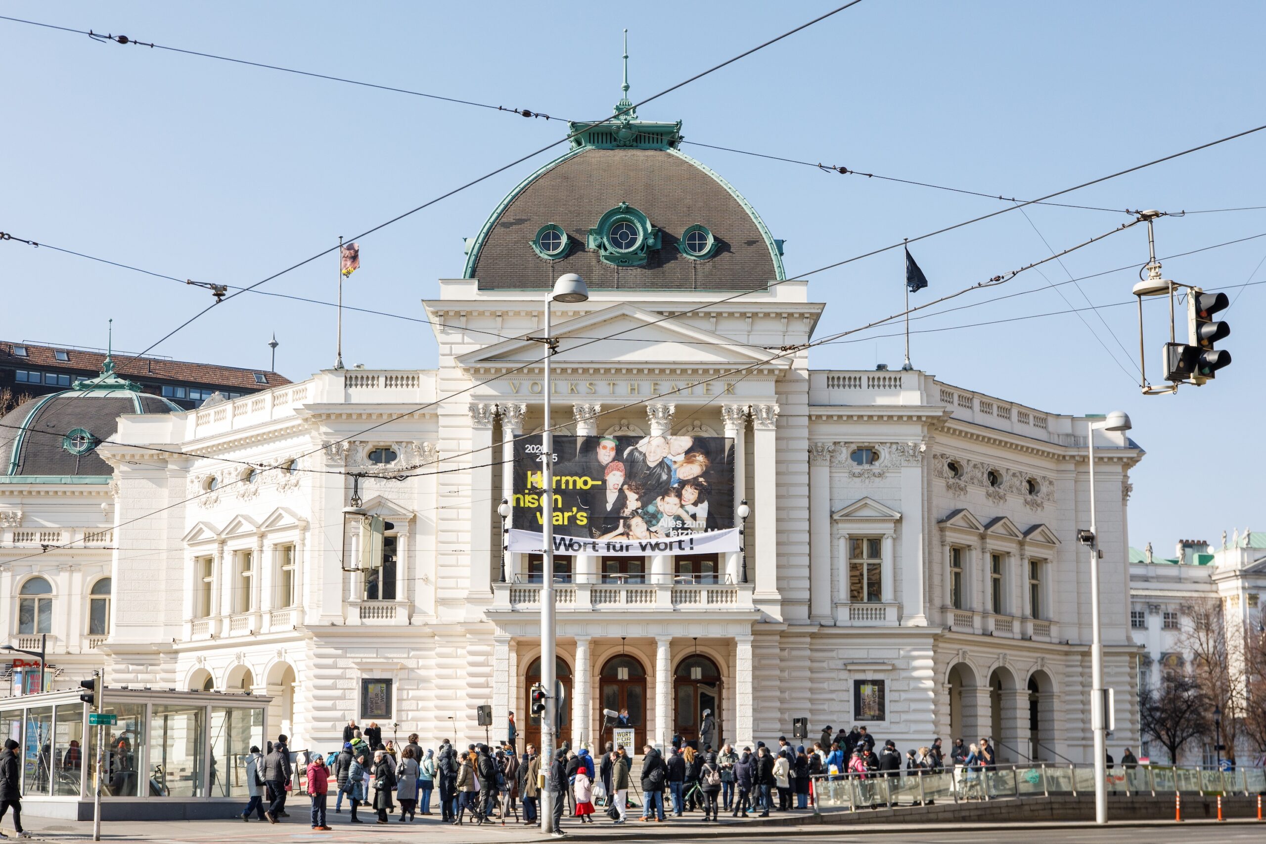 Menschenansammlung von Mitwirkenden im Projekt WORT FÜR WORT von Gerhard Rühm vor dem Volkstheater Wien