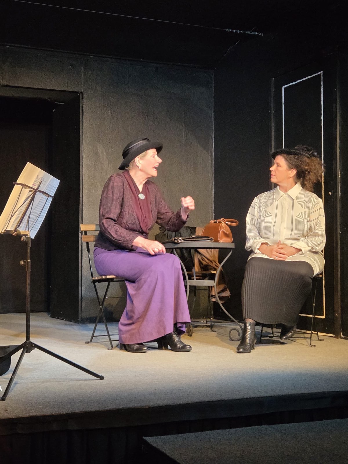 Auguste Fickert und Rosa Mayreder sind im Volksgartencafé, neben ihnen spielt eine Cellistin